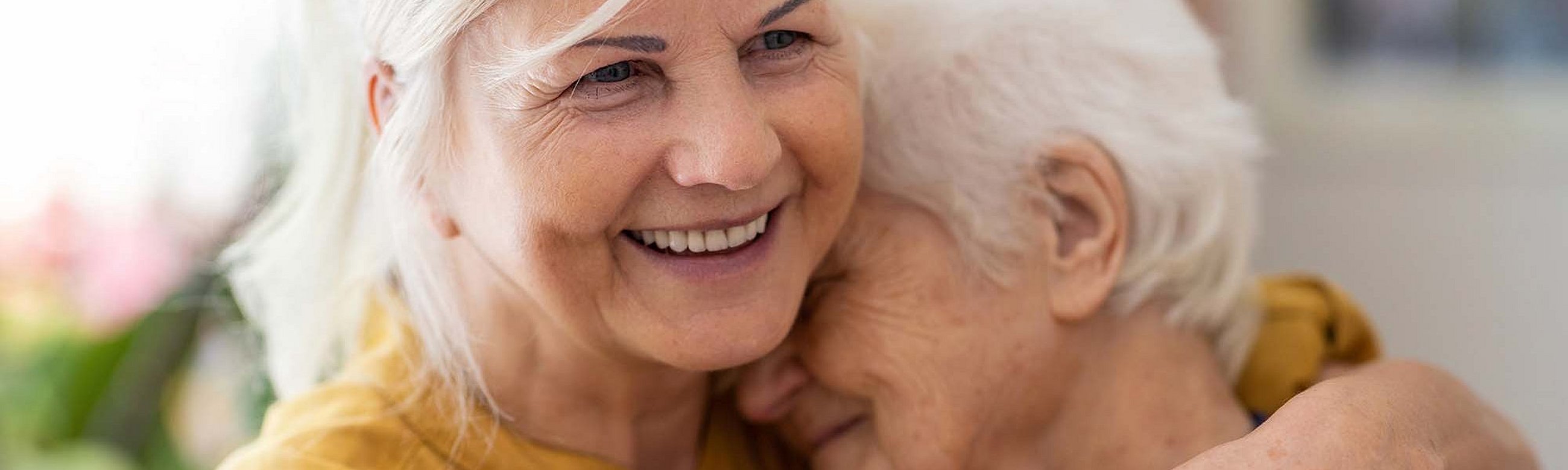 Frau hält ältere Frau im Arm