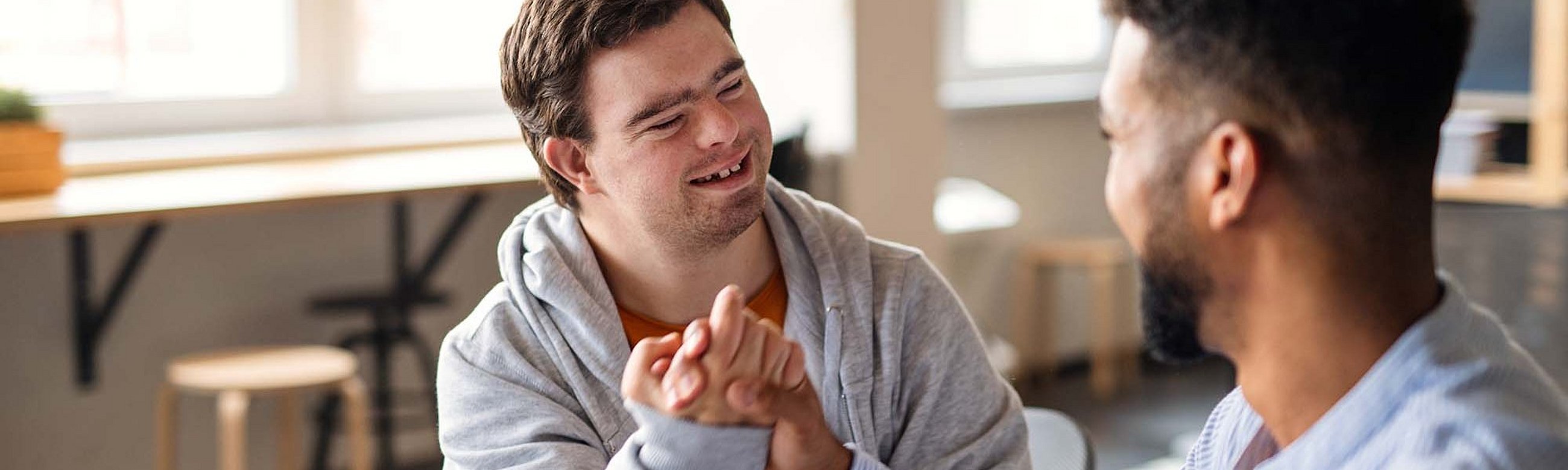 Zwei Männer, einer davon mit Down Syndrom, machen einen Bro-Handshake